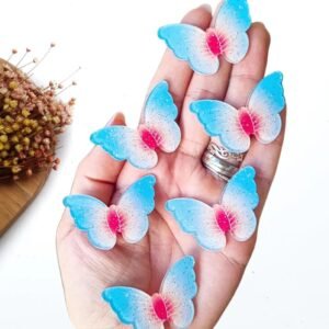 APLIQUE ACRÍLICO BORBOLETA GLITTER AZUL BEBÊ/VERMELHO C/ 2 UND