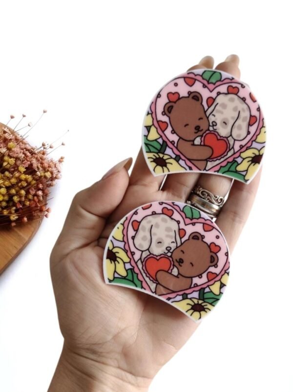 PAR DE ORELHAS EM ACRÍLICO BOBBIE GOODS URSINHO E CACHORRINHO CORAÇÃO COLORIDO 6,3CM UND
