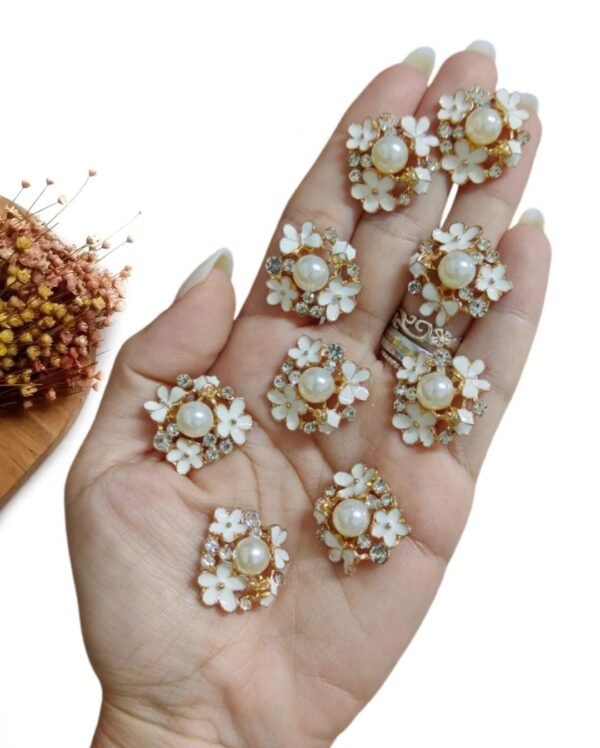 JOIA EM METAL FLORES BRANCAS E PÉROLA 2,4CM UND