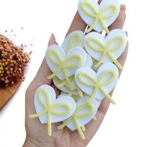 APLIQUE CORAÇÃO EM ACRÍLICO 2D LACINHOS AMARELO 4 CM UND
