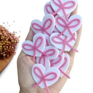 APLIQUE CORAÇÃO EM ACRÍLICO 2D LACINHOS ROSA 4 CM UND