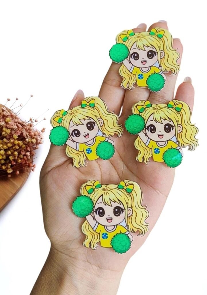 APLIQUE EM ACRÍLICO SUBLIMADO MENININHA MASCOTE DA COPA C/ POMPOM VERDE 4 CM UND