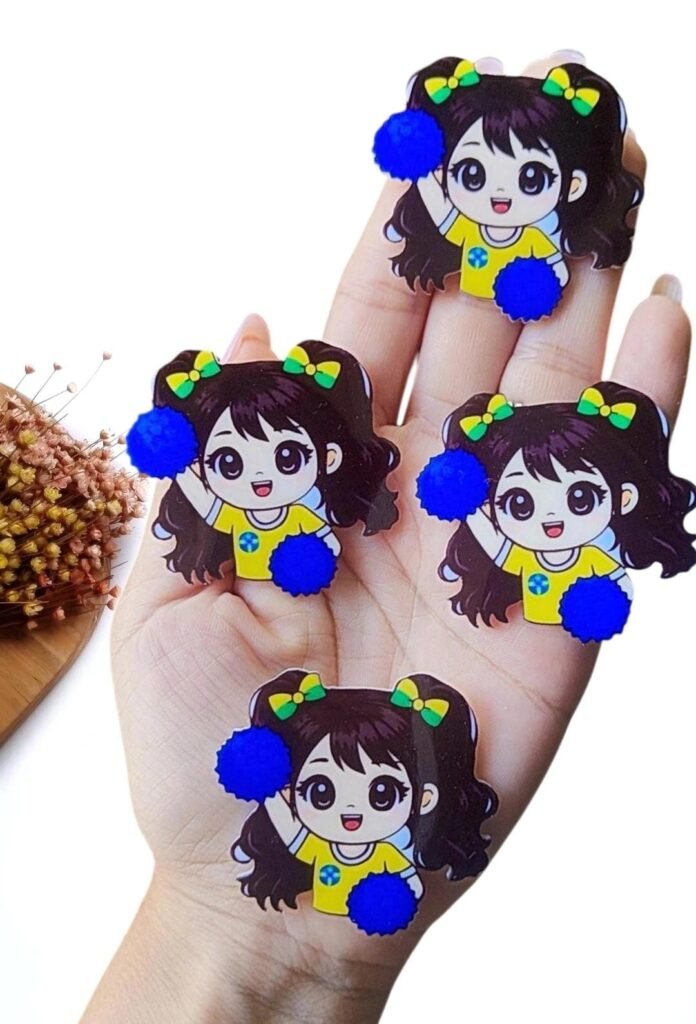 APLIQUE EM ACRÍLICO SUBLIMADO MENININHA MASCOTE DA COPA C/ POMPOM AZUL BIC 4 CM UND