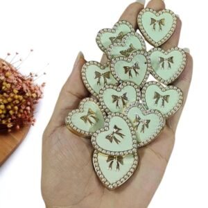 JOIA EM PLÁSTICO CORAÇÃO BRANCO C/ LAÇO E PÉROLAS 3CM UND
