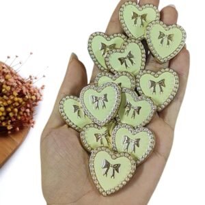 JOIA EM PLÁSTICO CORAÇÃO MARFIM C/ LAÇO E PÉROLAS 3CM UND