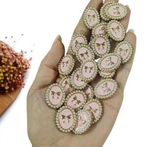 JOIA EM PLÁSTICO OVAL ROSA C/ LAÇO E PÉROLAS 2,2CM UND