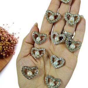 JOIA EM PLÁSTICO CORAÇÃO VAZADO C/ STRASS E PEROLA 2,2 CM C/ 2 UND